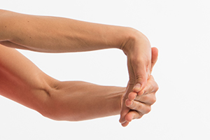 Person pulling down on fingers with one hand to extend the wrist of other hand