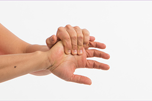 Person stretching the right hand wrist by pulling the hand toward their body with left hand