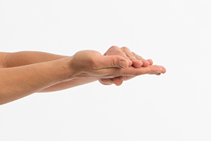 Person holding their hand palm up, with the other hand resting on top of fingers