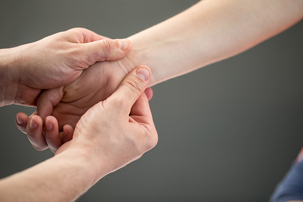 Hand massage -- two hands massaging another person's wrist