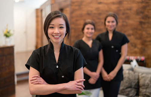 Portrait of Asian woman working at spa with a group of women in background