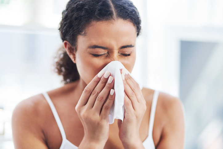 Woman blowing her nose with tissue