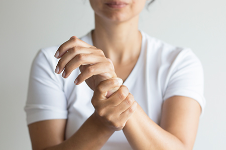 woman holding a sore wrist