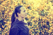 Peaceful woman in a field looking up with positive emotion